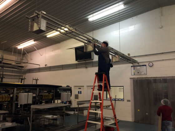 A man fixing an electrical requirement for a facility